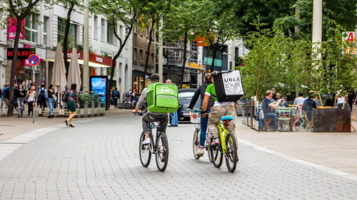 Uber Eats delivery cyclists riding urban street