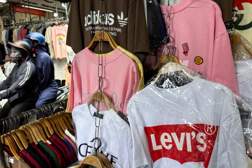 Branded casual tee apparel hanging at street market stall