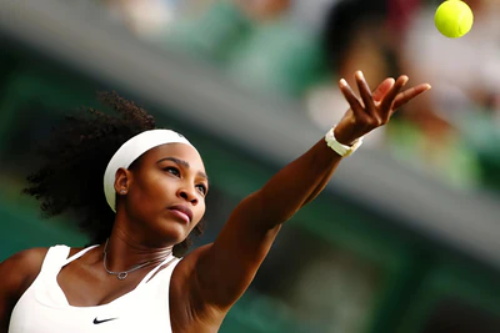 Serena Williams tossing tennis ball to serve