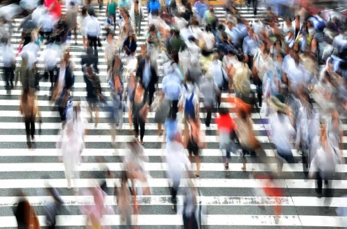 Motion-blurred crowd crossing city pedestrian crosswalk