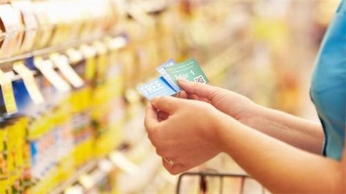 Hands holding discount coupons inside supermarket