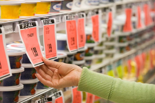 Hand checking red special offer price tag in grocery store